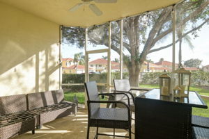 Screened-in lanai that has a walk out to grassy area and community pool just steps away