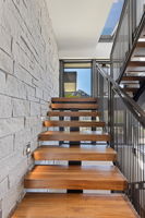 Floating walnut stairs lead to the roof top deck.