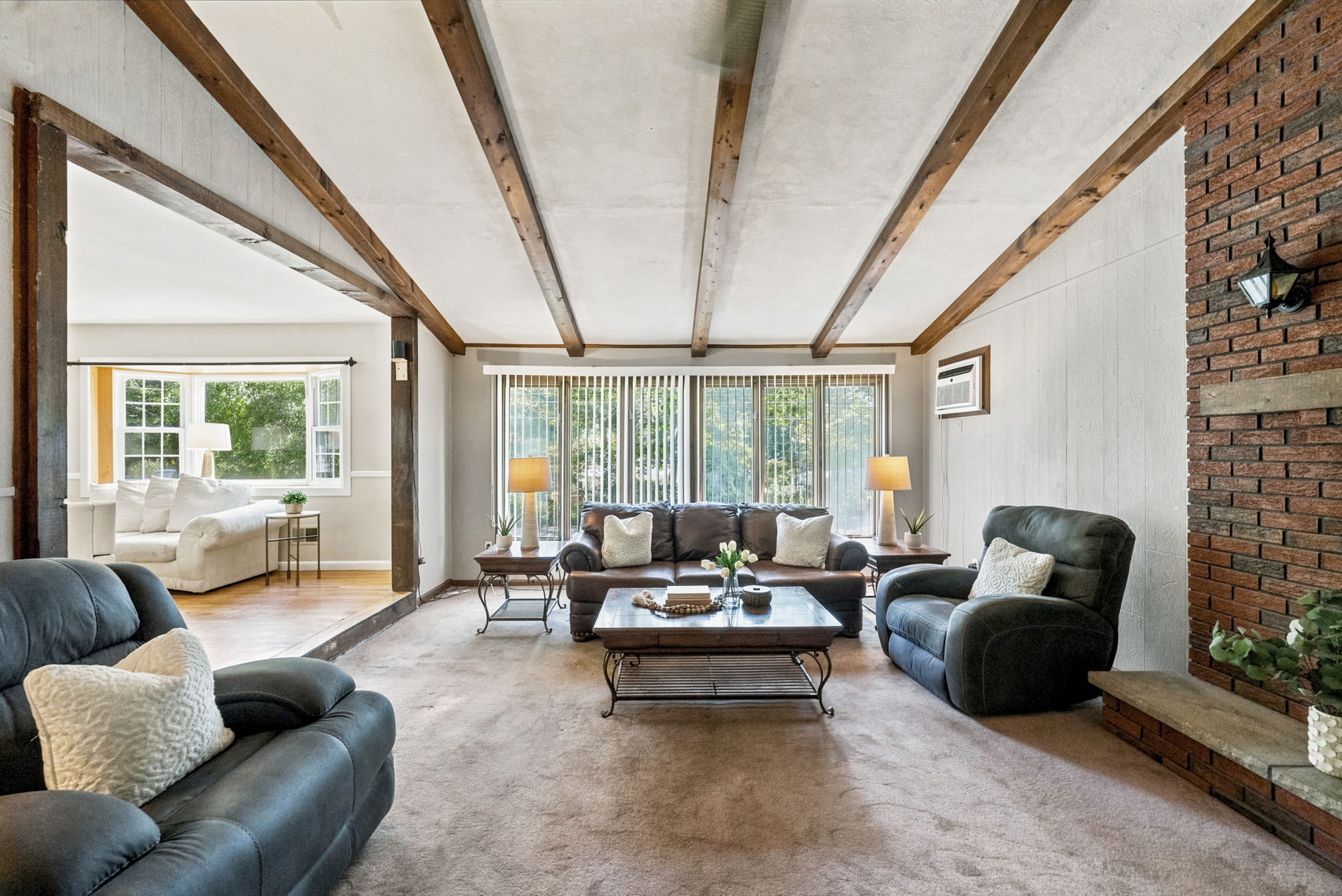 Inside, the spacious great room makes an immediate impression with its soaring cathedral ceiling, exposed dark wood beams, dramatic center truss and full brick wall with a wood-burning fireplace. The large eat-in kitchen features a center island and sliding doors leading to an impressive 25-by-25-foot deck overlooking a private, tree-lined backyard.