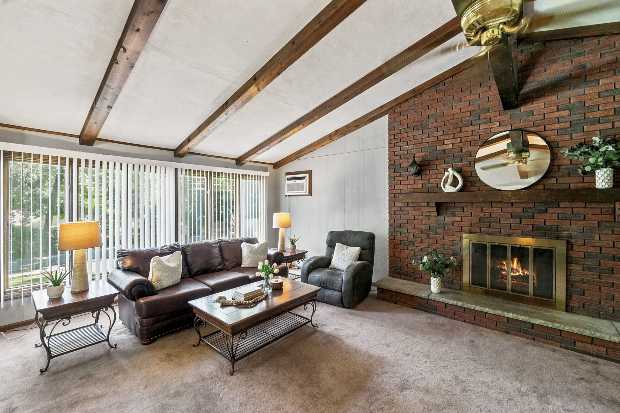Inside, the spacious great room makes an immediate impression with its soaring cathedral ceiling, exposed dark wood beams, dramatic center truss and full brick wall with a wood-burning fireplace. The large eat-in kitchen features a center island and sliding doors leading to an impressive 25-by-25-foot deck overlooking a private, tree-lined backyard.