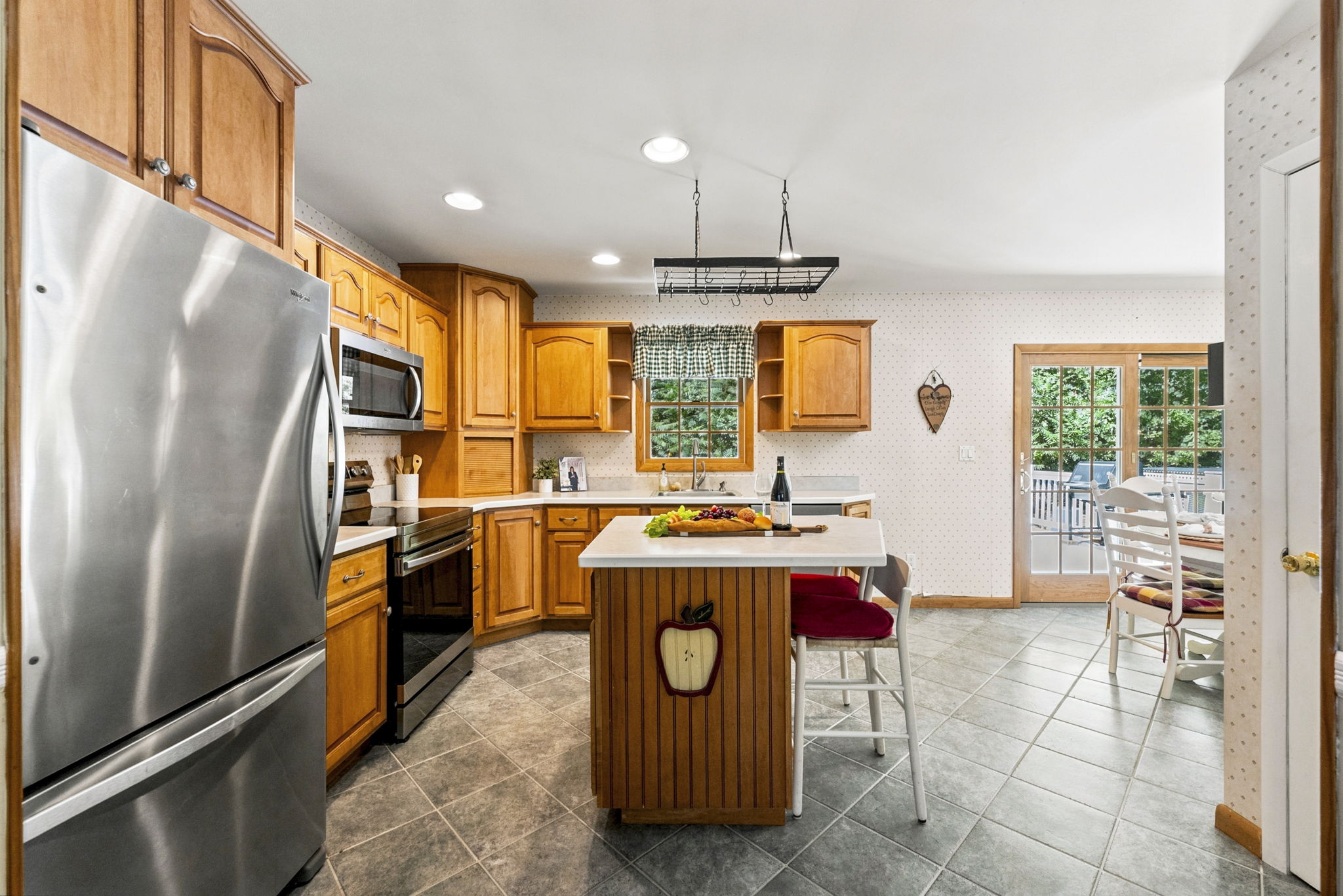 The large eat-in kitchen provides plenty of room to cook and gather, with a center island and sliding doors opening to an impressive 25-by-25-foot deck.
