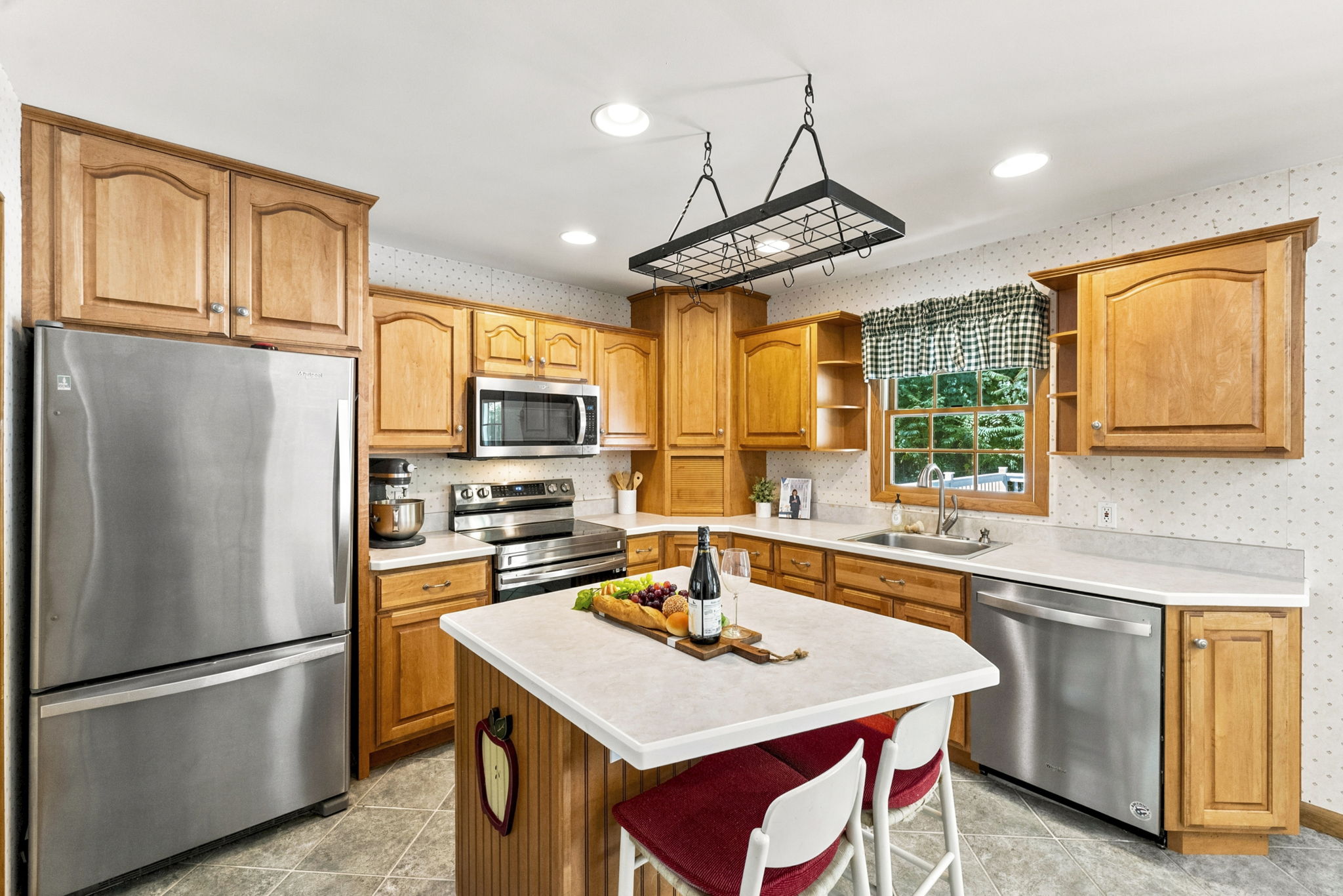 The large eat-in kitchen provides plenty of room to cook and gather, with a center island and sliding doors opening to an impressive 25-by-25-foot deck.