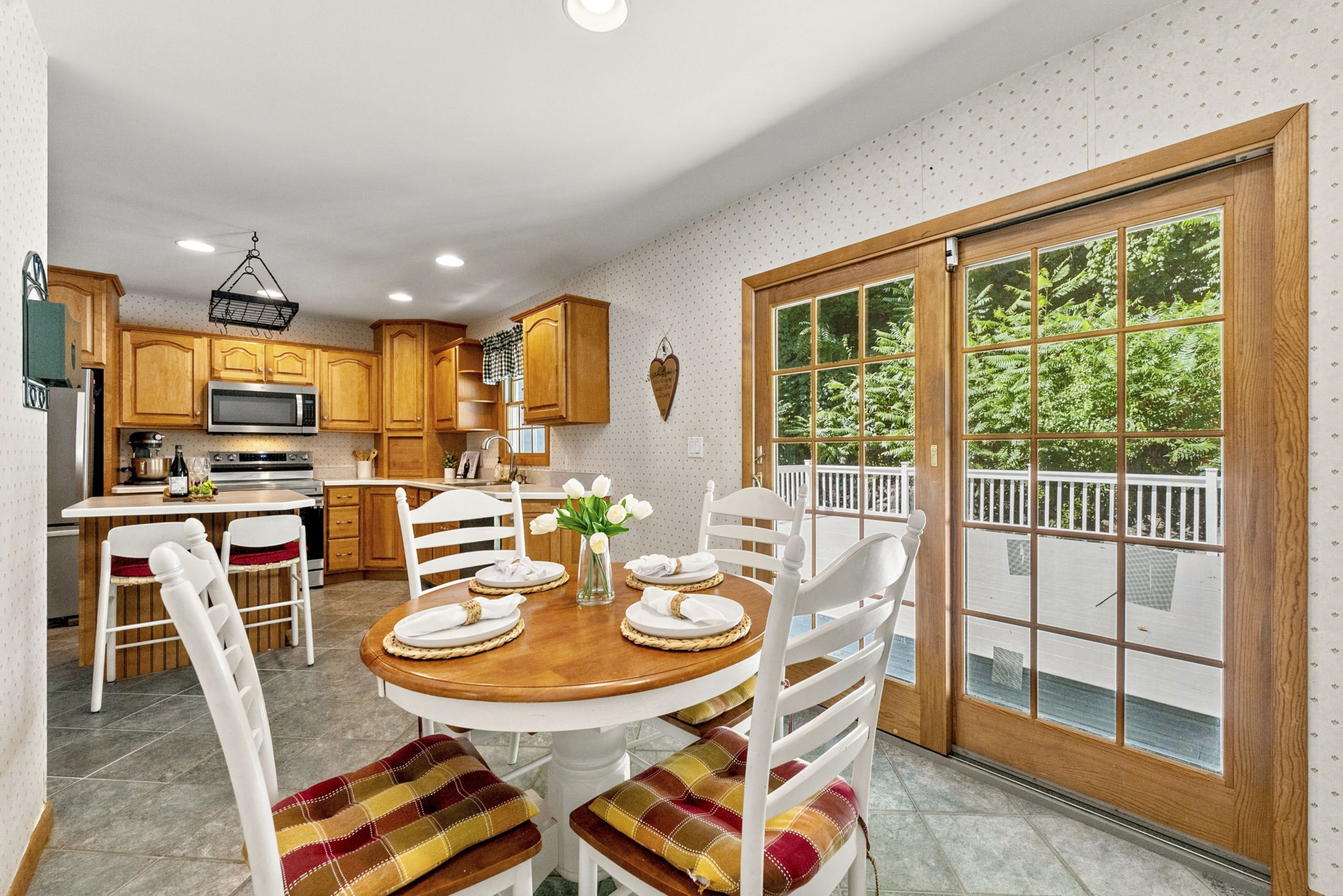 The large eat-in kitchen provides plenty of room to cook and gather, with a center island and sliding doors opening to an impressive 25-by-25-foot deck.