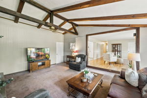 Inside, the spacious great room makes an immediate impression with its soaring cathedral ceiling, exposed dark wood beams, dramatic center truss and full brick wall with a wood-burning fireplace. The large eat-in kitchen features a center island and sliding doors leading to an impressive 25-by-25-foot deck overlooking a private, tree-lined backyard.