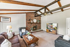 Inside, the spacious great room makes an immediate impression with its soaring cathedral ceiling, exposed dark wood beams, dramatic center truss and full brick wall with a wood-burning fireplace. The large eat-in kitchen features a center island and sliding doors leading to an impressive 25-by-25-foot deck overlooking a private, tree-lined backyard.