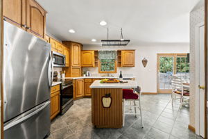 The large eat-in kitchen provides plenty of room to cook and gather, with a center island and sliding doors opening to an impressive 25-by-25-foot deck.