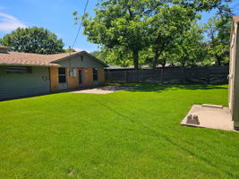 Fenced backyard featuring a patio area. The Tuff Shed is on the right.