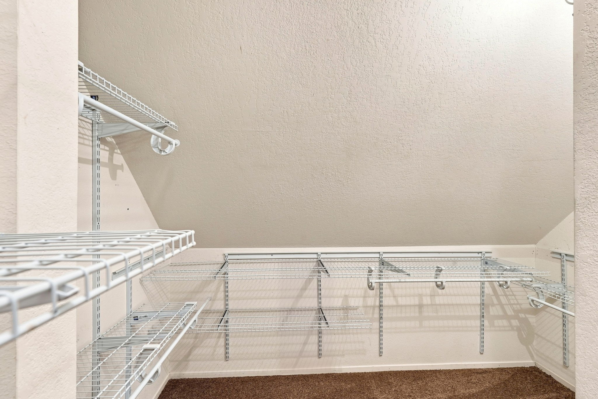 L-shaped primary closet with wire storage system