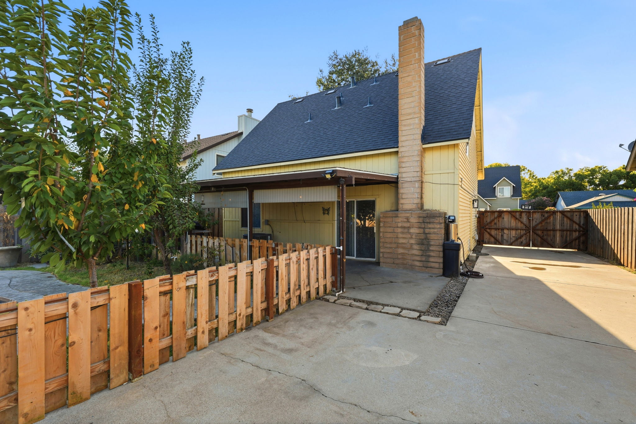 Rear exterior with covered patio and gated driveway