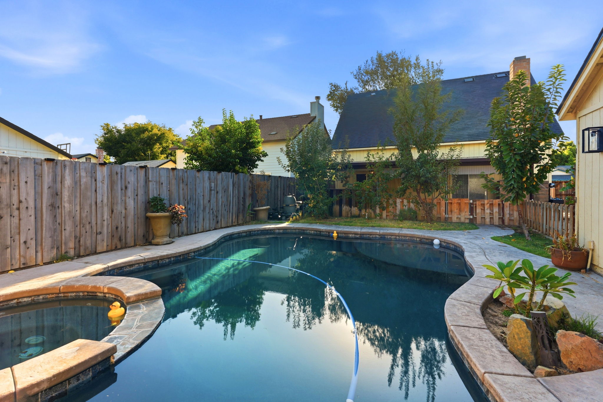 Pool and spa with rear exterior view