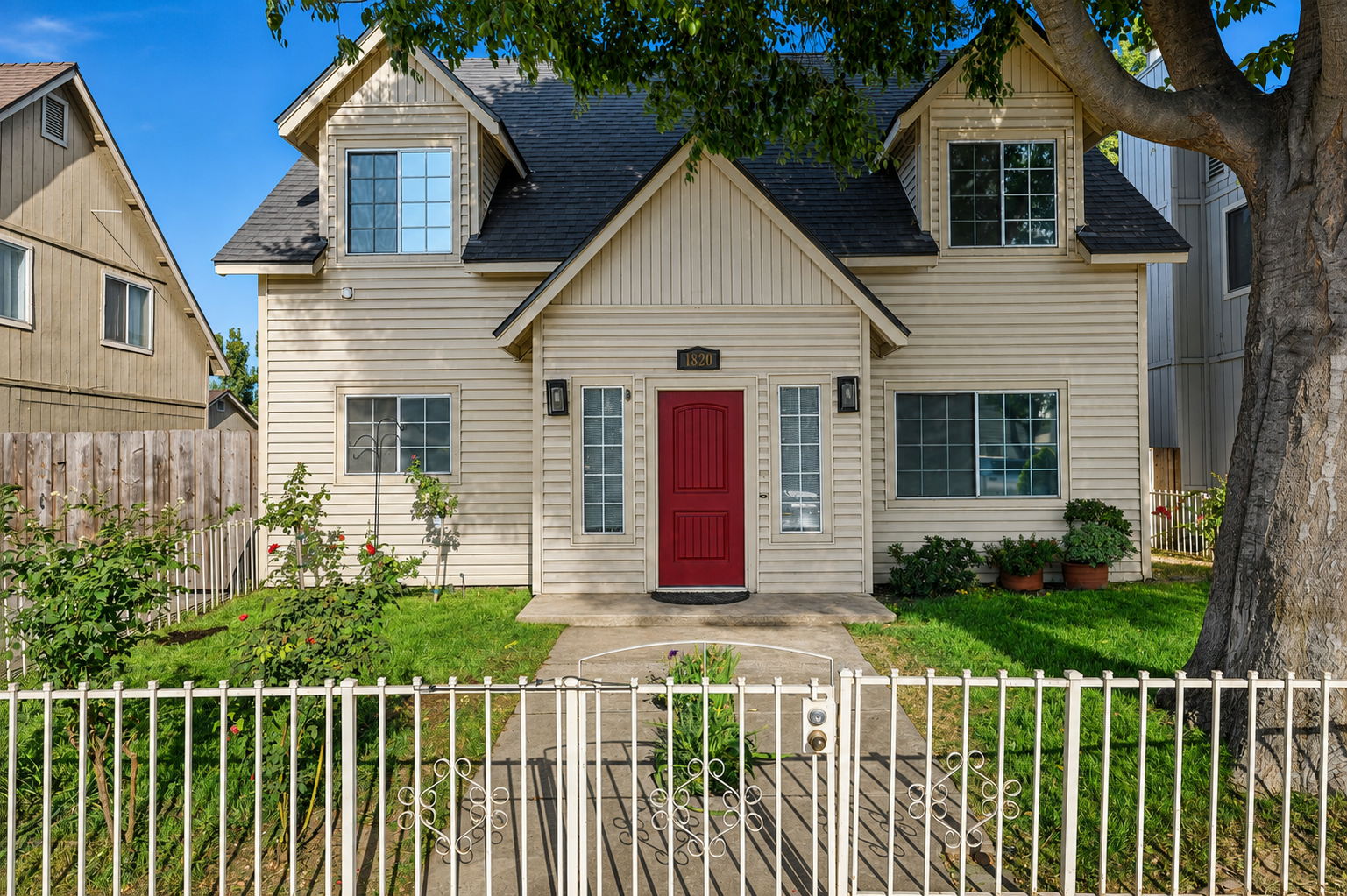 Front exterior with red entry door and mature shade tree