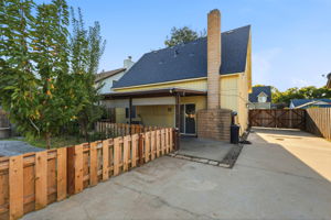 Rear exterior with covered patio and gated driveway