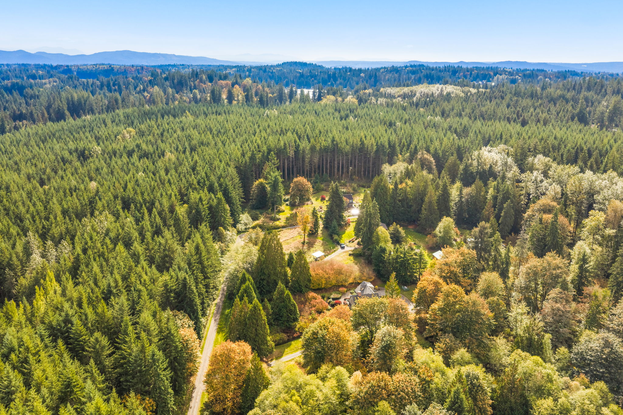 A wide aerial view captures the home’s peaceful rural setting, with Flowing Lake Park visible in the distance.