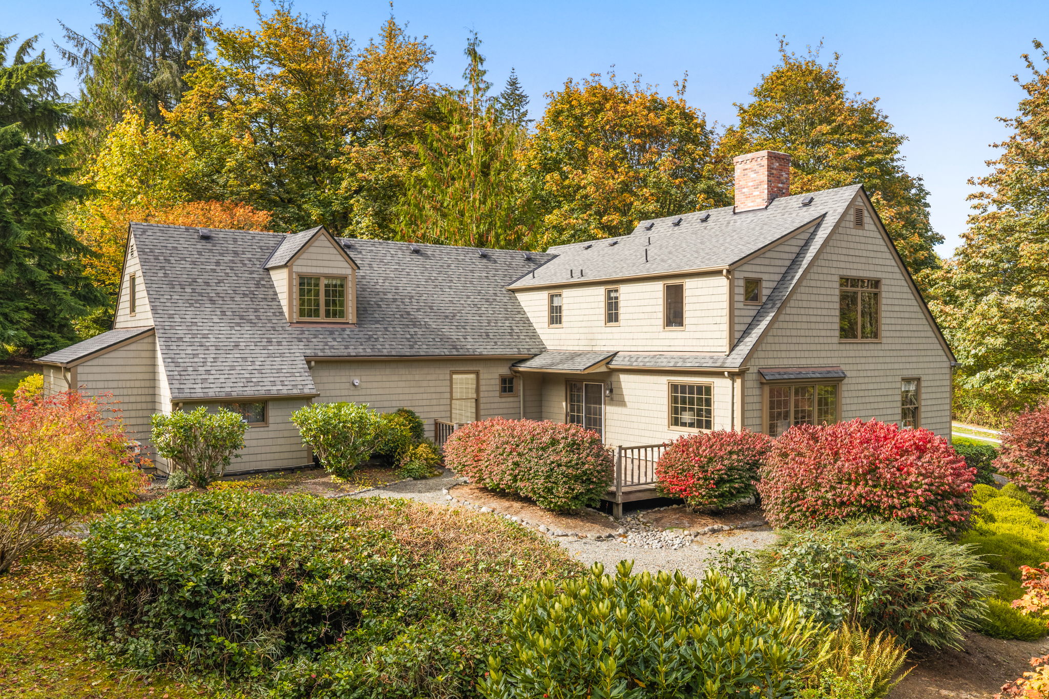 Colorful garden beds and winding gravel paths surround the rear deck, offering plenty of reasons to step outside.