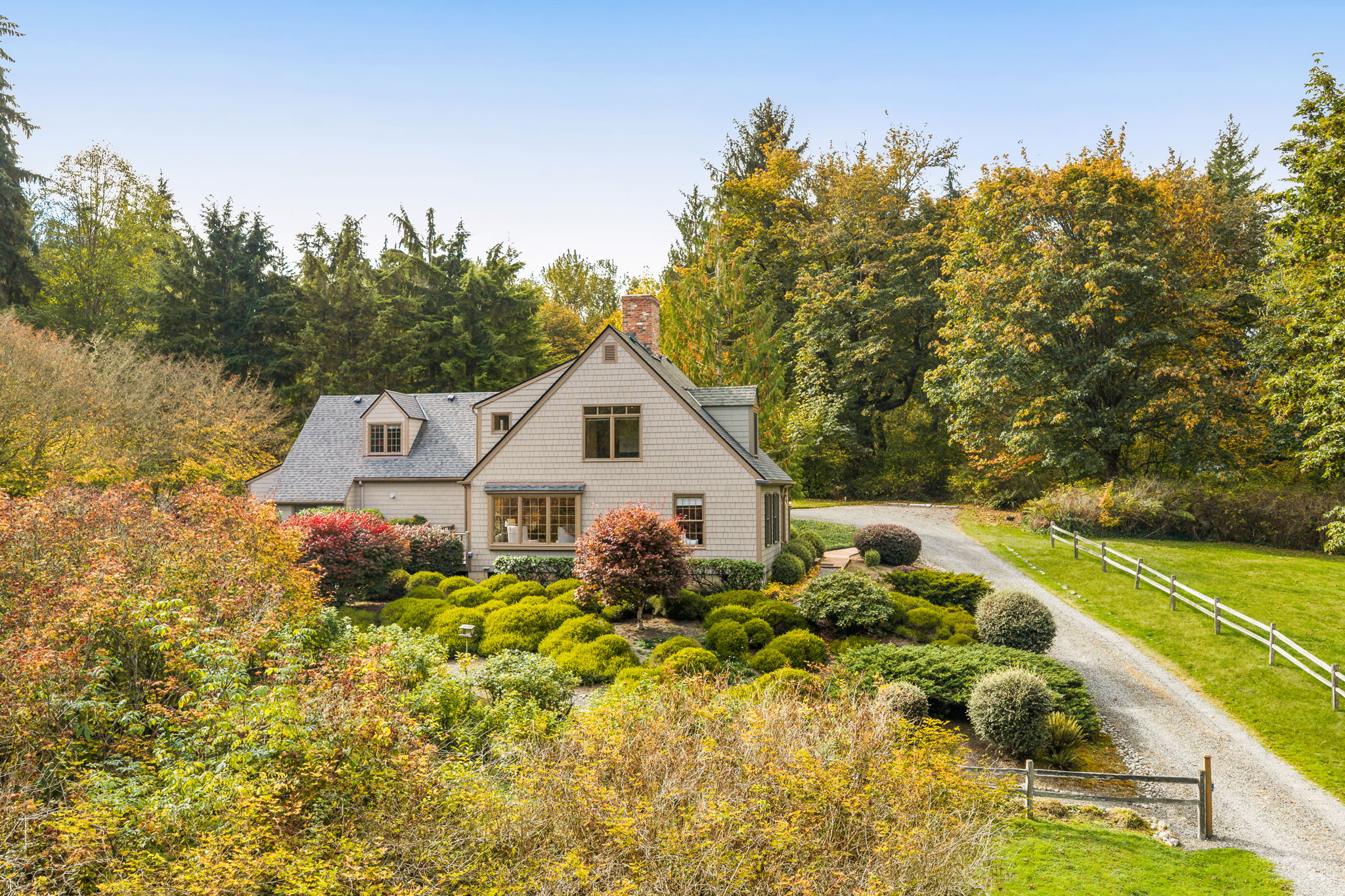 A split-rail fence adds rustic charm and a country feel along the dedicated driveway..