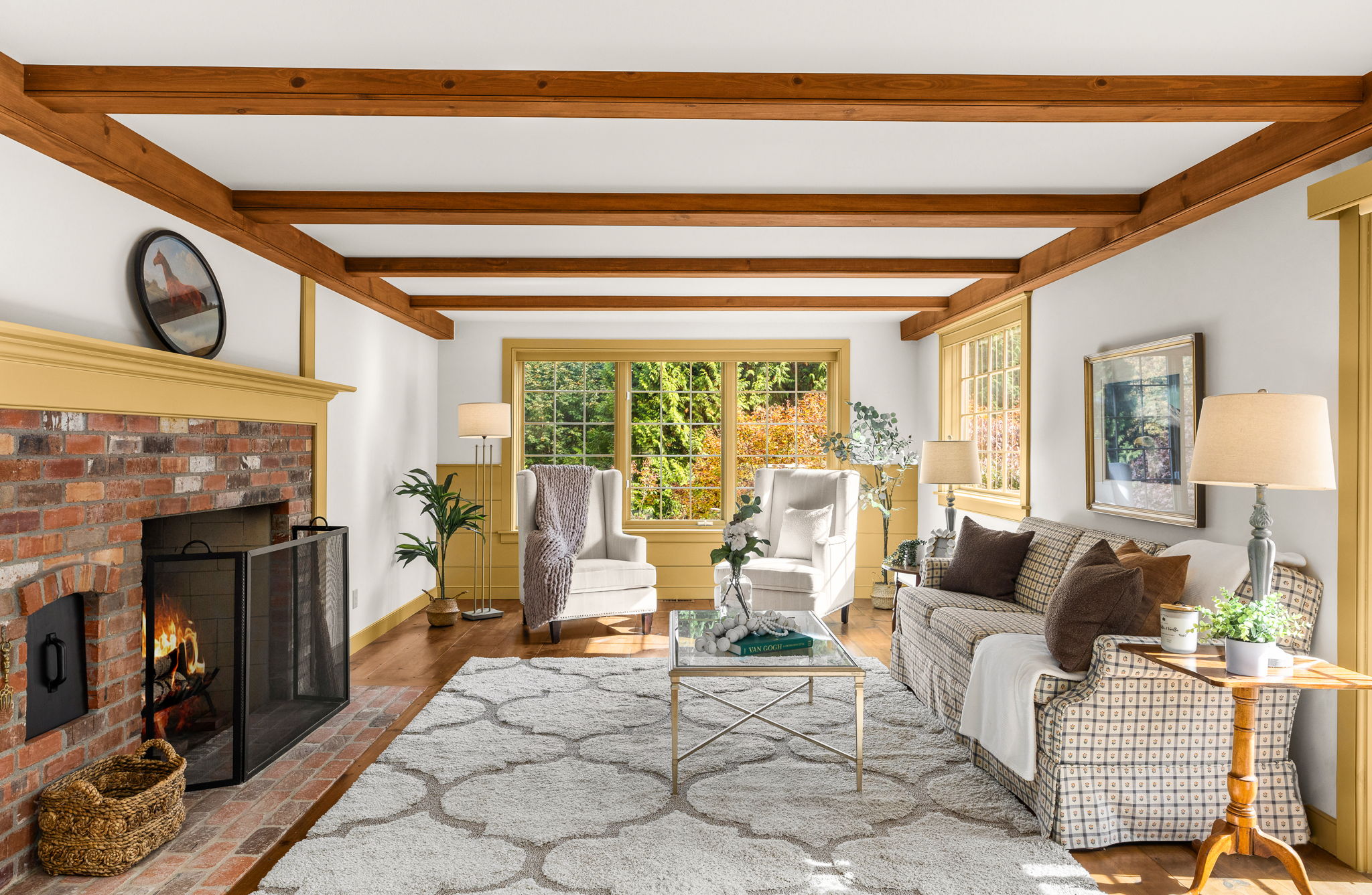 Gather in the family room, where exposed beams, a glowing brick fireplace, and leafy views set the scene for relaxed afternoons.