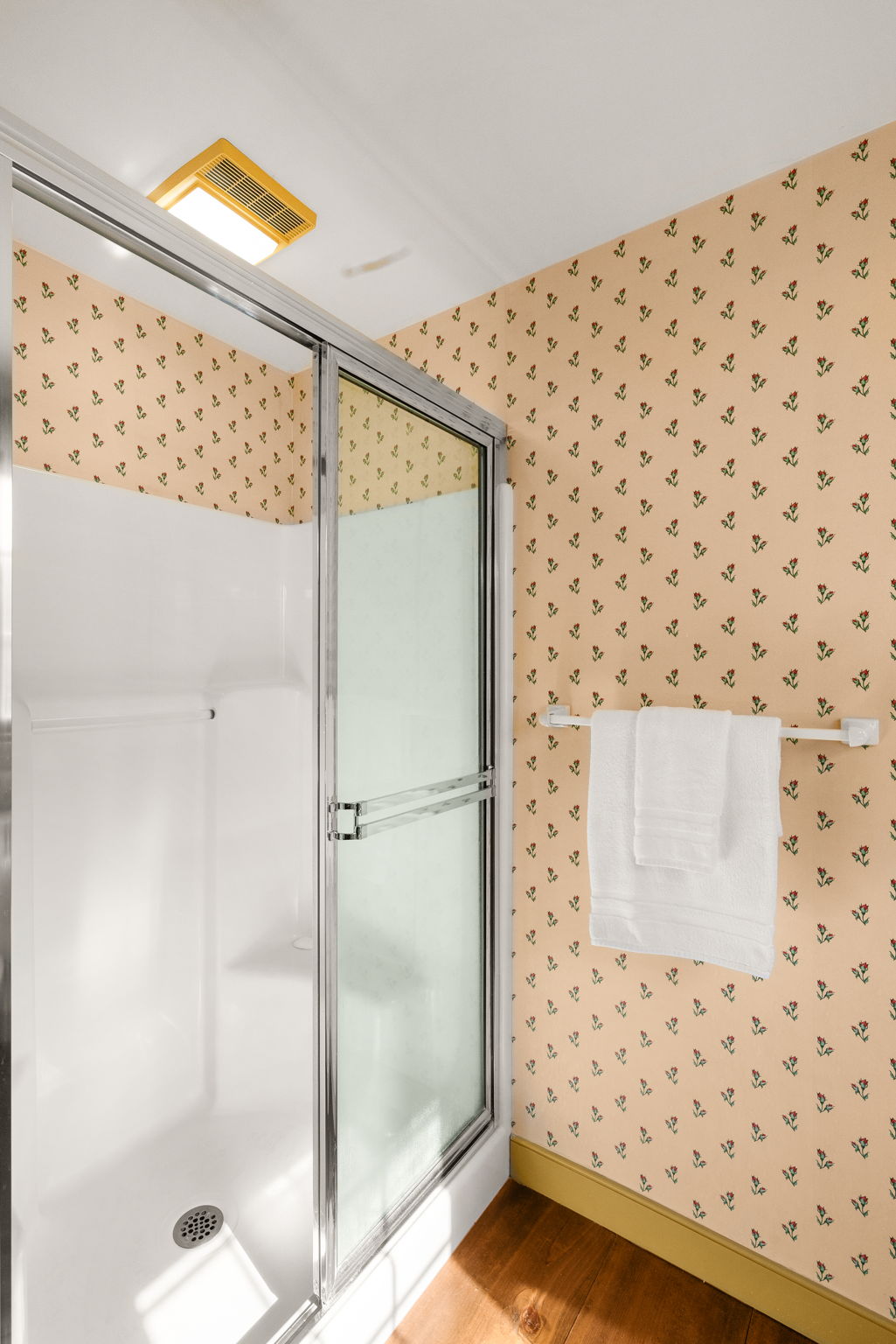 A glass-enclosed shower completes the primary three-quarter bath.