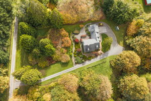 An overhead view showcases the pristine property and a sweeping driveway with room to maneuver.