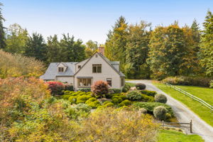 A split-rail fence adds rustic charm and a country feel along the dedicated driveway..