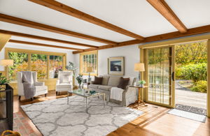 Sunlight fills the family room, where a sliding glass door opens to the deck and lush garden beyond.