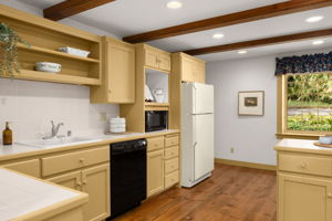 A garden-facing window brings natural light into the kitchen, while a dedicated microwave nook keeps counters clear.