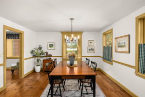 A candle-style chandelier sets the scene for memorable dinners, with the kitchen conveniently close by.