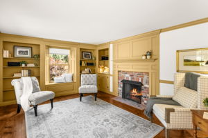 Built-in bookshelves, a cozy window seat, and a glowing brick fireplace make this library or den an inviting spot to settle in with a favorite book.