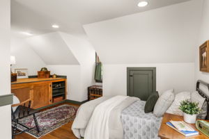 The spacious second-floor bedroom has two distinct areas, with this sleeping nook tucked beneath sloped ceilings.