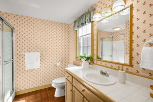 The primary three-quarter bath features a spacious vanity and a glass-enclosed shower.