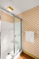 A glass-enclosed shower completes the primary three-quarter bath.