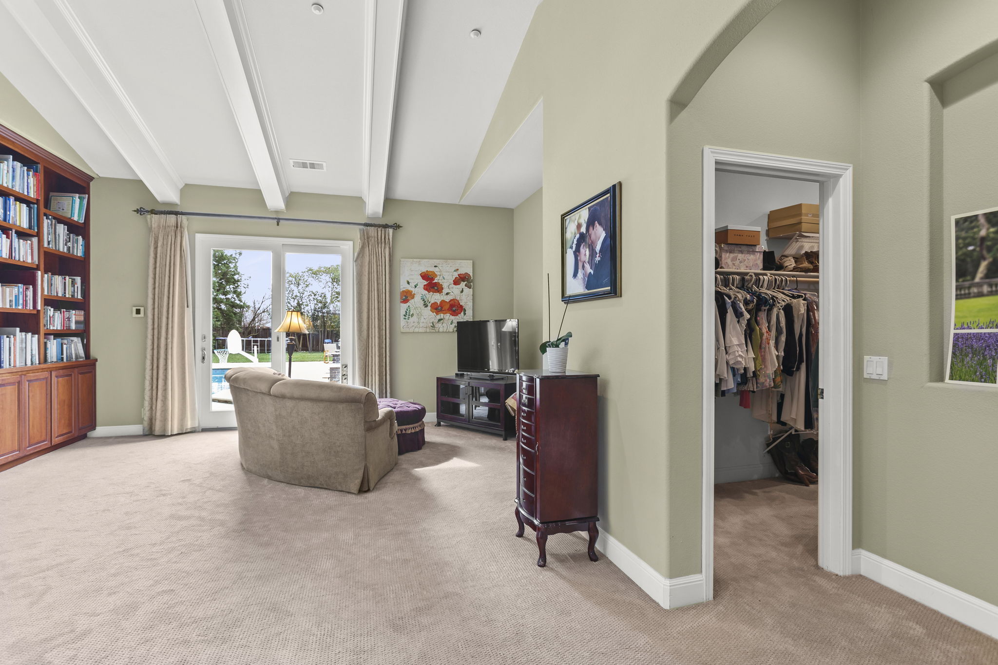 Huge primary/master bedroom suite with view to backyard and French doors out to pool & spa. Entrance to massive walk-in closet and bath suite on right.