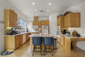 Island kitchen with walk-in pantry in rear of photo