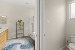 Secondary master bedroom's bath suite with double sink vanity and separate shower & tub. Private commode area on right