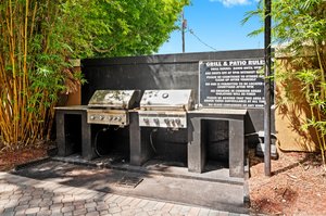 Twin stainless steel BBQ's by the pool plus a shady seating area