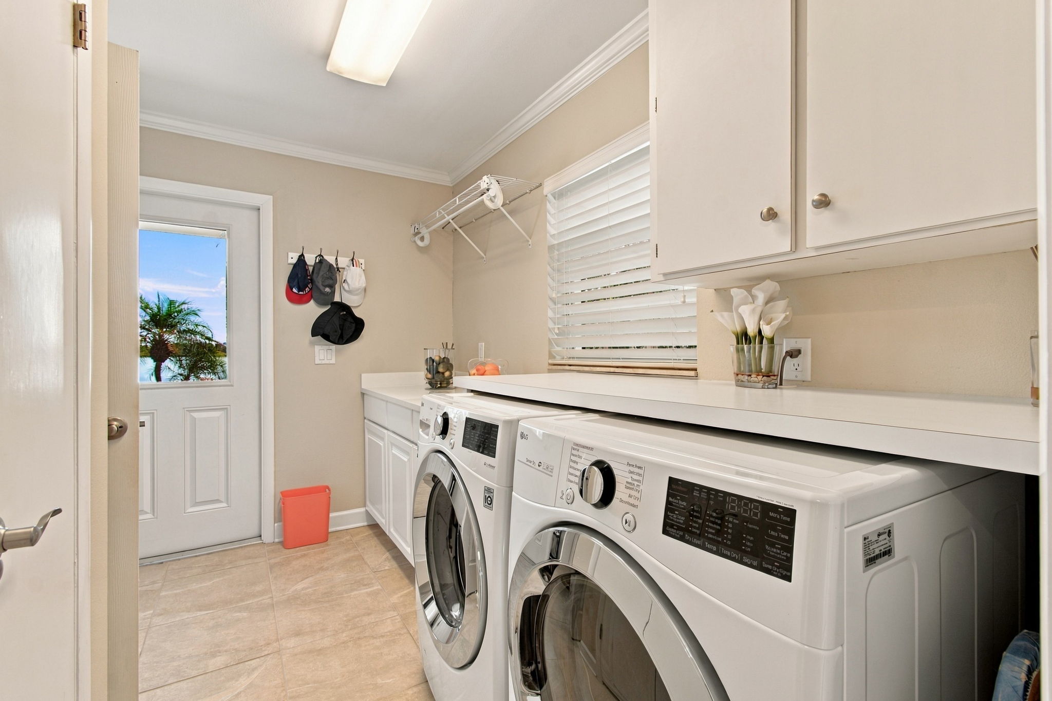 Laundry room with built-in cabinets, countertop & storage closet