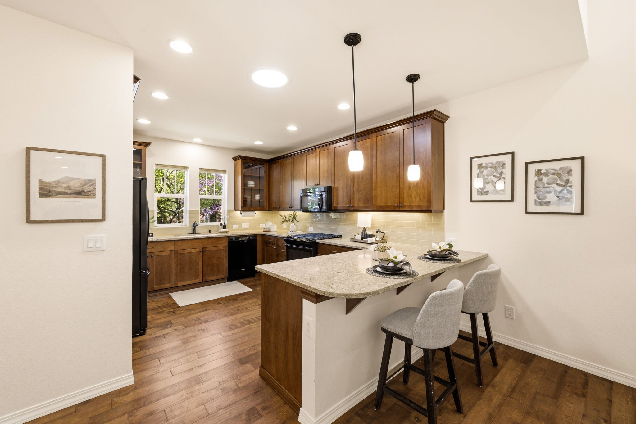 Kitchen. Warm wood cabinetry pairs with a spacious island and pendant lighting for casual dining or meal prep.