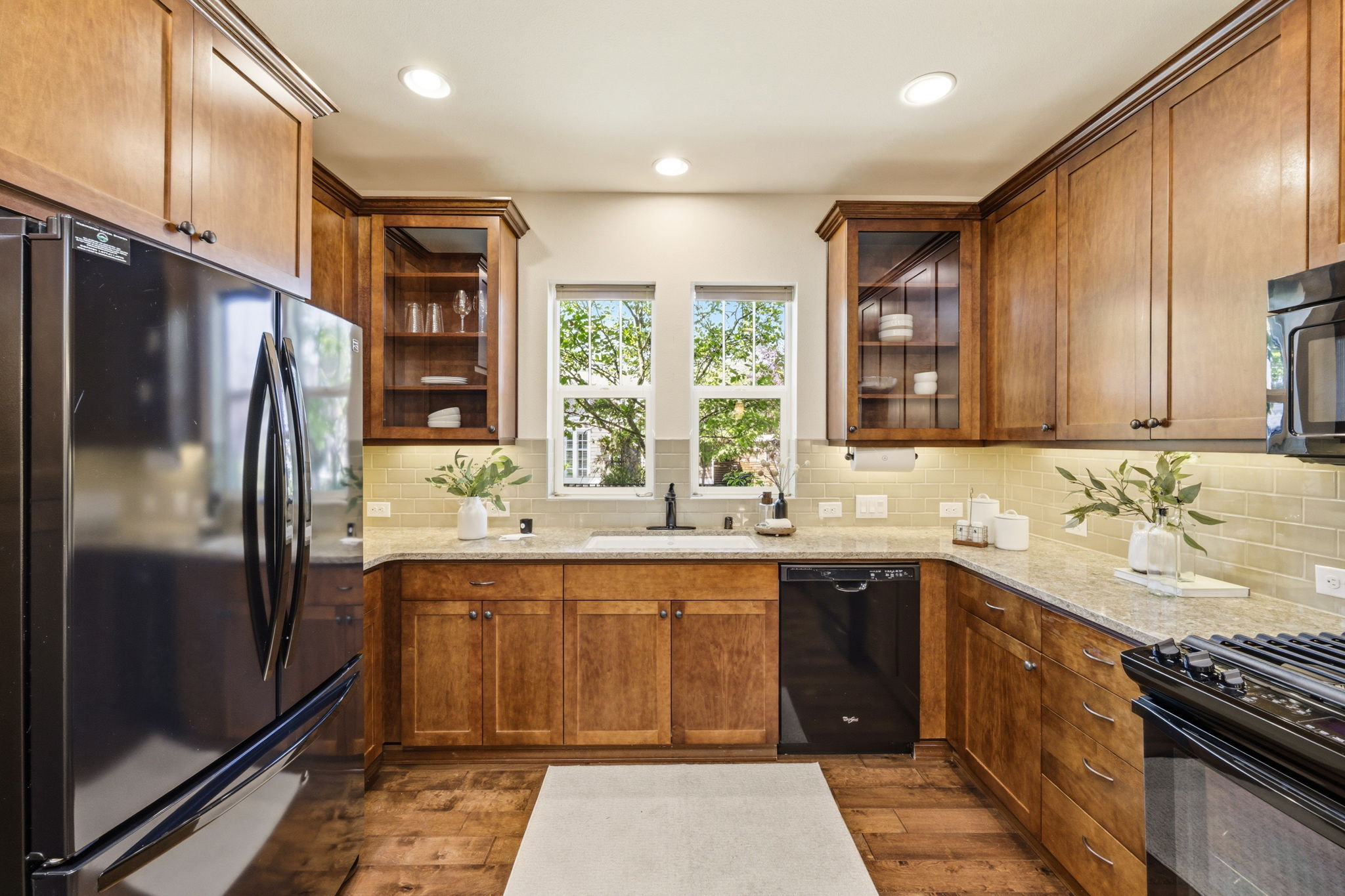 Kitchen. A window above the sink brings in natural light, complemented by tile backsplash and ample cabinetry.