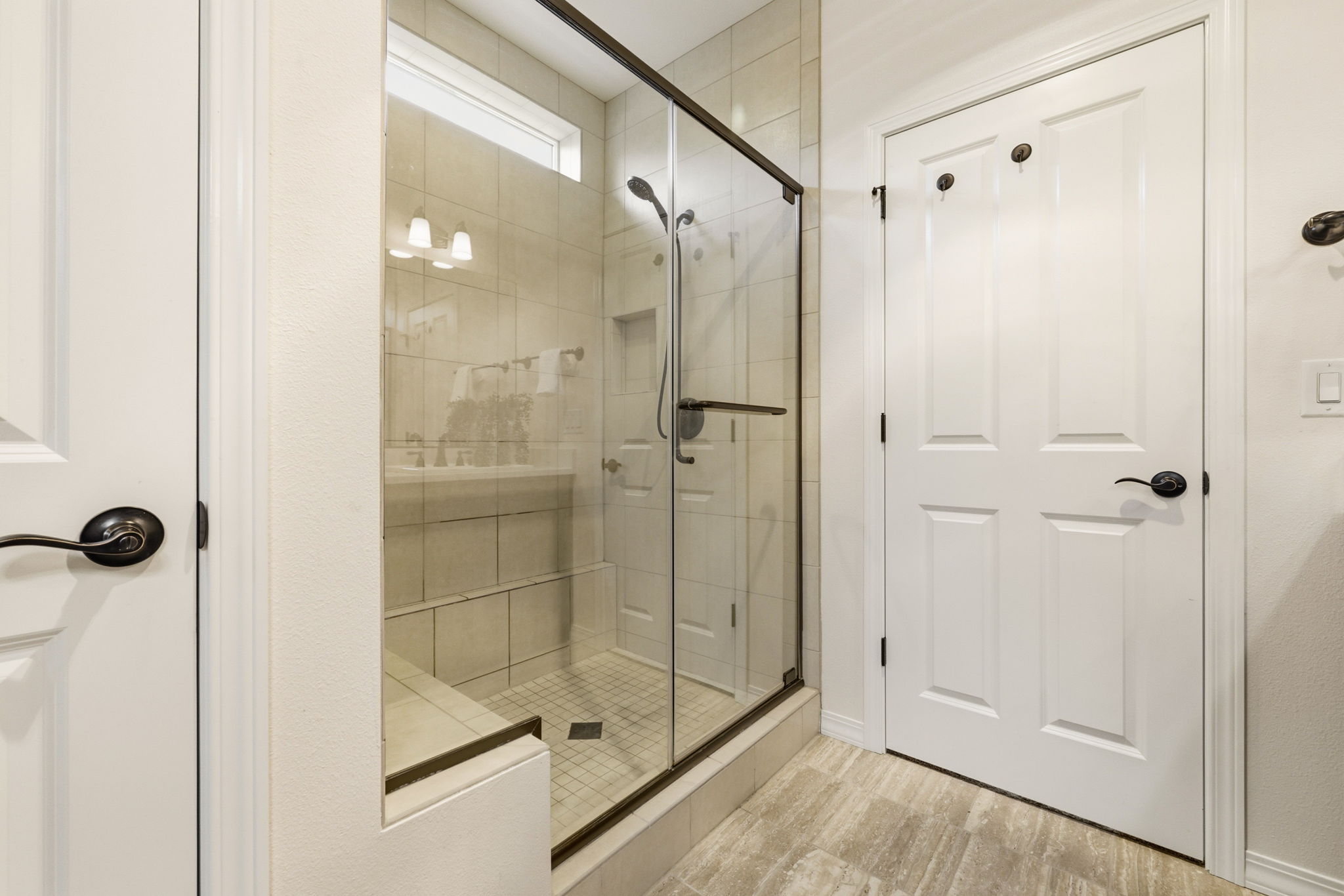 Primary Bathroom. A glass-enclosed tile shower adds a spa-like touch to the space.