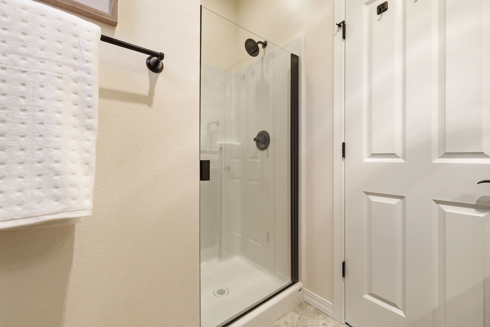 Bathroom. A glass-enclosed shower with tile surround offers a clean, modern finish.