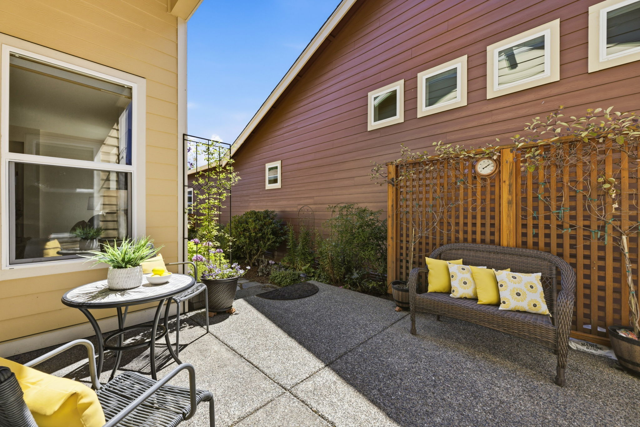 Patio. A wood privacy screen and cozy bench seating add charm to this outdoor retreat.