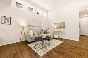 Living Room. Soft neutral tones and a plush area rug create a relaxed gathering space beneath tall clerestory windows.