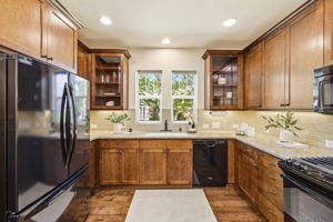 Kitchen. A window above the sink brings in natural light, complemented by tile backsplash and ample cabinetry.