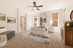 Primary Bedroom. A generous layout with plush carpet and a cozy sitting area provides a private retreat.