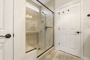 Primary Bathroom. A glass-enclosed tile shower adds a spa-like touch to the space.