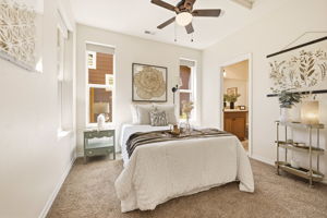 Bedroom. A bright, carpeted room with a ceiling fan offers a comfortable and versatile space.