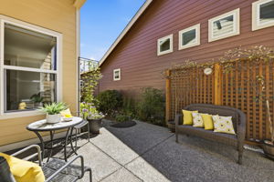 Patio. A wood privacy screen and cozy bench seating add charm to this outdoor retreat.