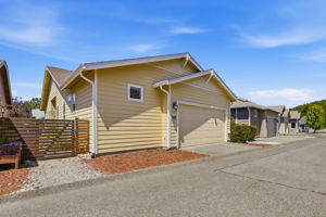 Garage access through alley. Low-maintenance gravel landscaping and fencing offer additional outdoor space.