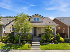 Front Exterior. Mature trees and layered greenery frame the covered entry and welcoming curb appeal.