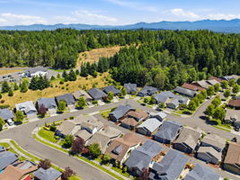 Aerial View. The home sits within an established neighborhood surrounded by mature trees and green space.