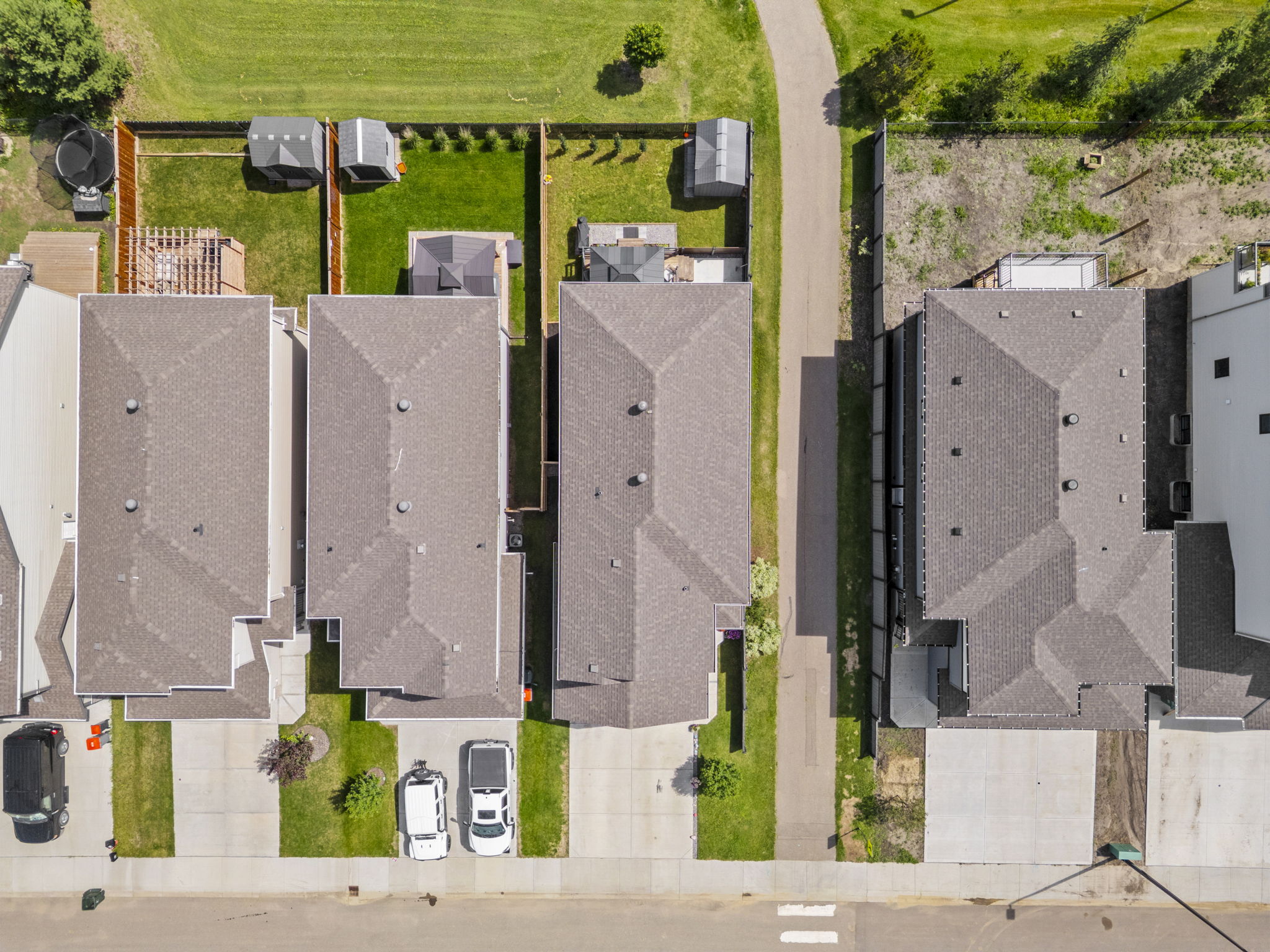 Overhead view of the home, driveway and narrow fenced backyard.